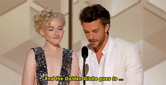 Actor Jonathan Bailey opens the envelope and announces the winner, alongside fellow presenter Julia Garner.